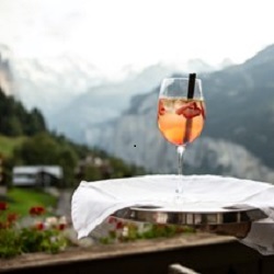 alcoholic cocktail being served on a tray by a waiter